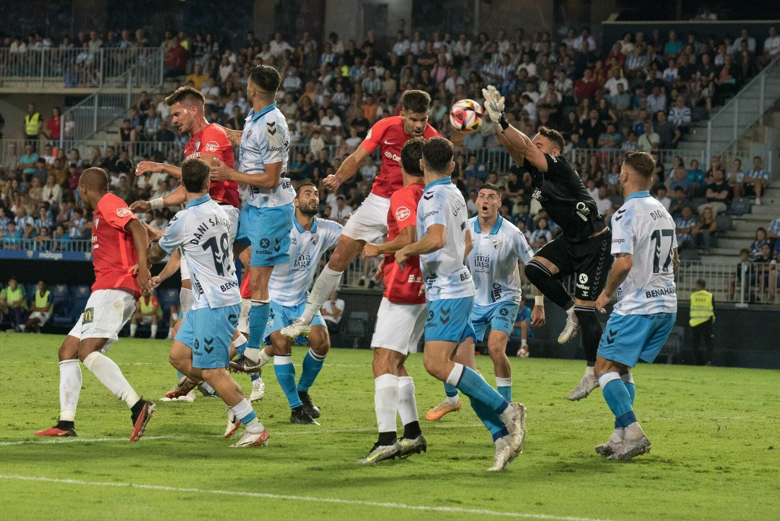 Carlos Blanco remata rodeado de futbolistas.