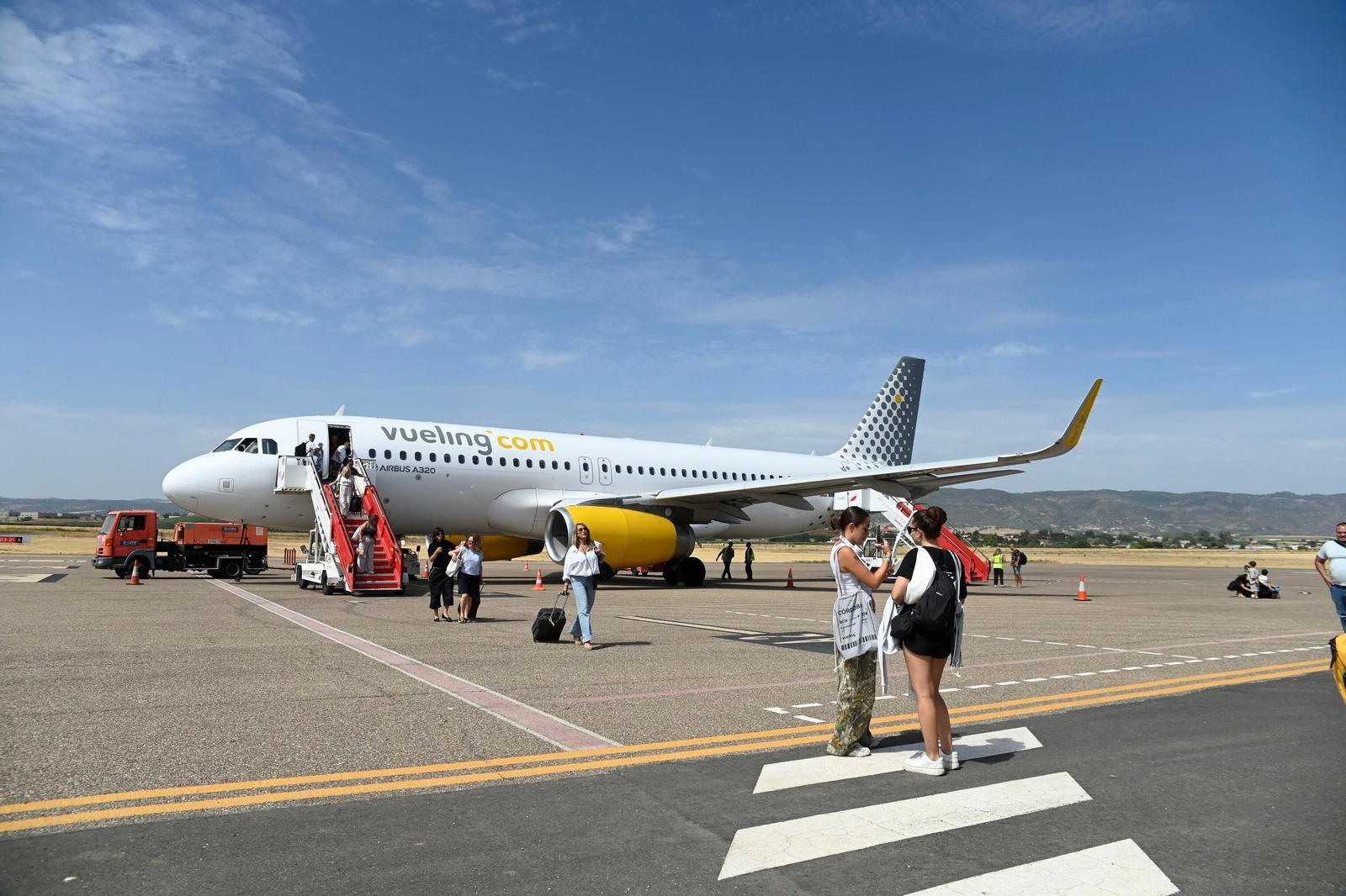 Los pasajeros descienden de un avión de Vueling tras un vuelo desde Barcelona.