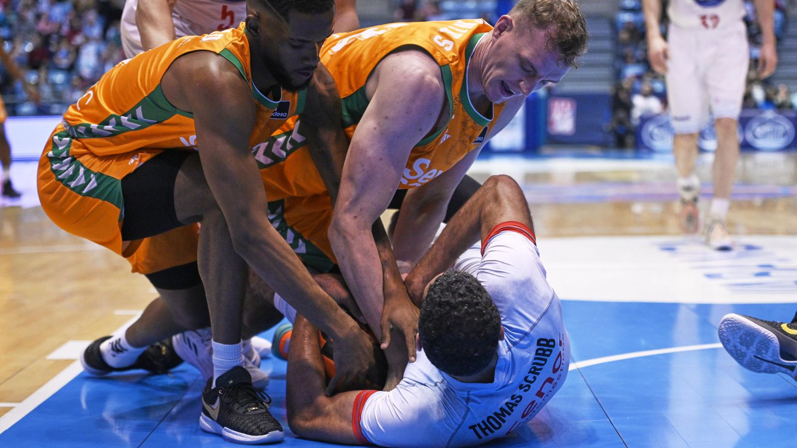 Pasecniks y Montero pelean la pelota con Thomas Scrubb.