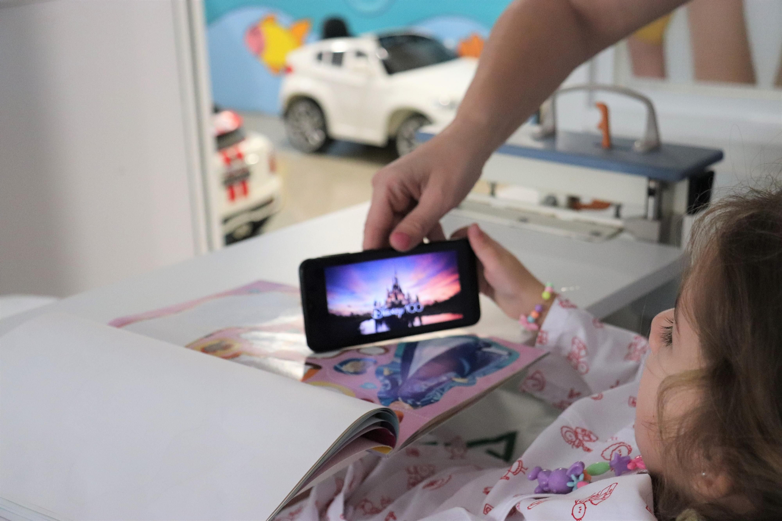 Una menor disfruta de la película de Peter Pan en Pediatría.