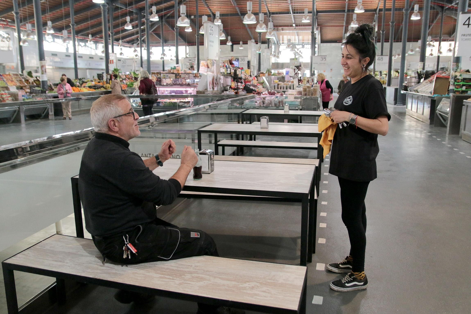 Ana Gutiérrez, de la cafetería La Plaza, atiende a uno de los clientes en la nueva zona ampliada de este negocio.