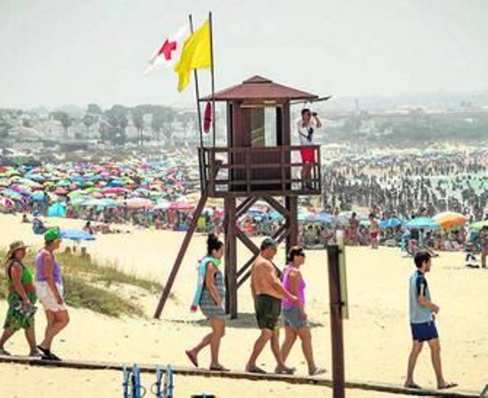 Ua torreta de la Cruz Roja en la playa de La Barrosa con la playa a tope de bañistas el pasado domingo.