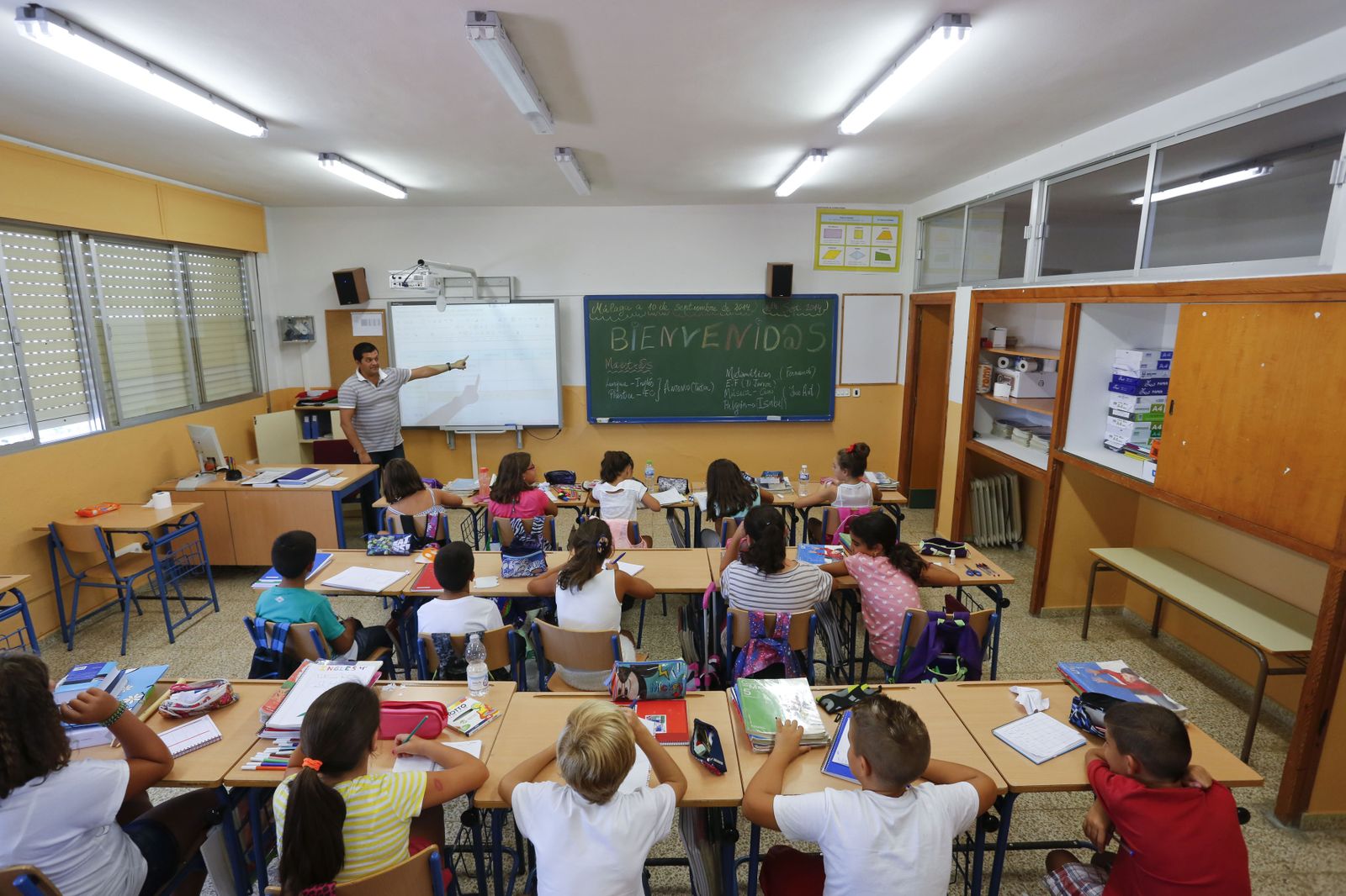 Estudiantes siguen las explicaciones del profesor en el aula.