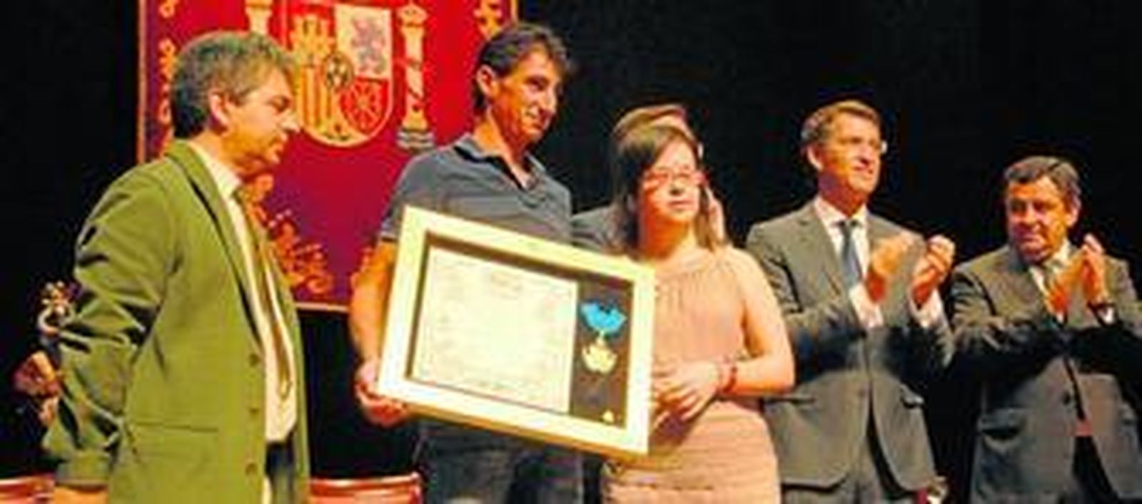 Isidoro Castaño y Francisco Otero, representantes de los vecinos de Angrois, reciben la medalla de oro de manos de Fátima Reyes, una de las isleñas que sobrevivió a la tragedia del Alvia.