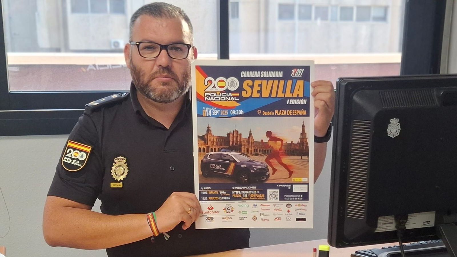 El portavoz de la Policía Nacional Raúl López muestra el cartel de la carrera.