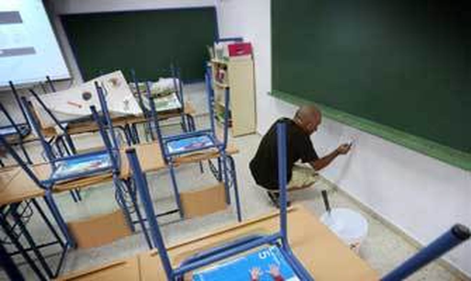 Un operario pinta las paredes de una de las clases del colegio Pío XII. /Miguel Ángel González