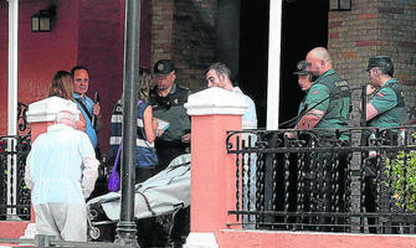 Los servicios funerarios retiran el cadaver del fallecido, el sábado en el bar de Lanjarón incendiado.