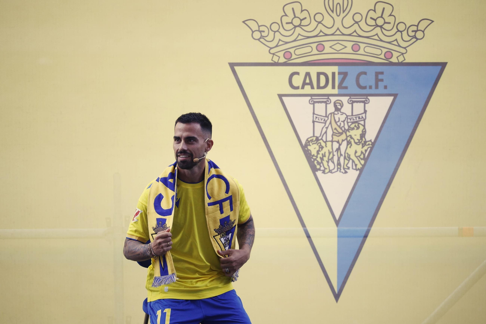 Suso con la bufanda del Cádiz y el escudo al fondo en el acto de presentación. Suso con la bufanda del Cádiz y el escudo al fondo en el acto de presentación.