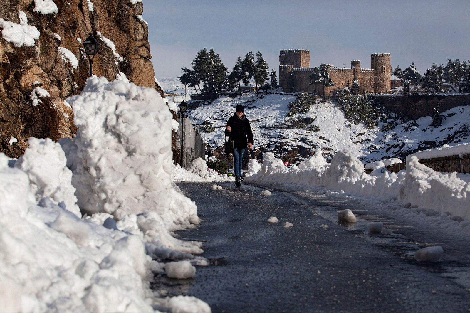Una mujer pasea por una calle de Toledo, aun con mucha nieve y hielo.
