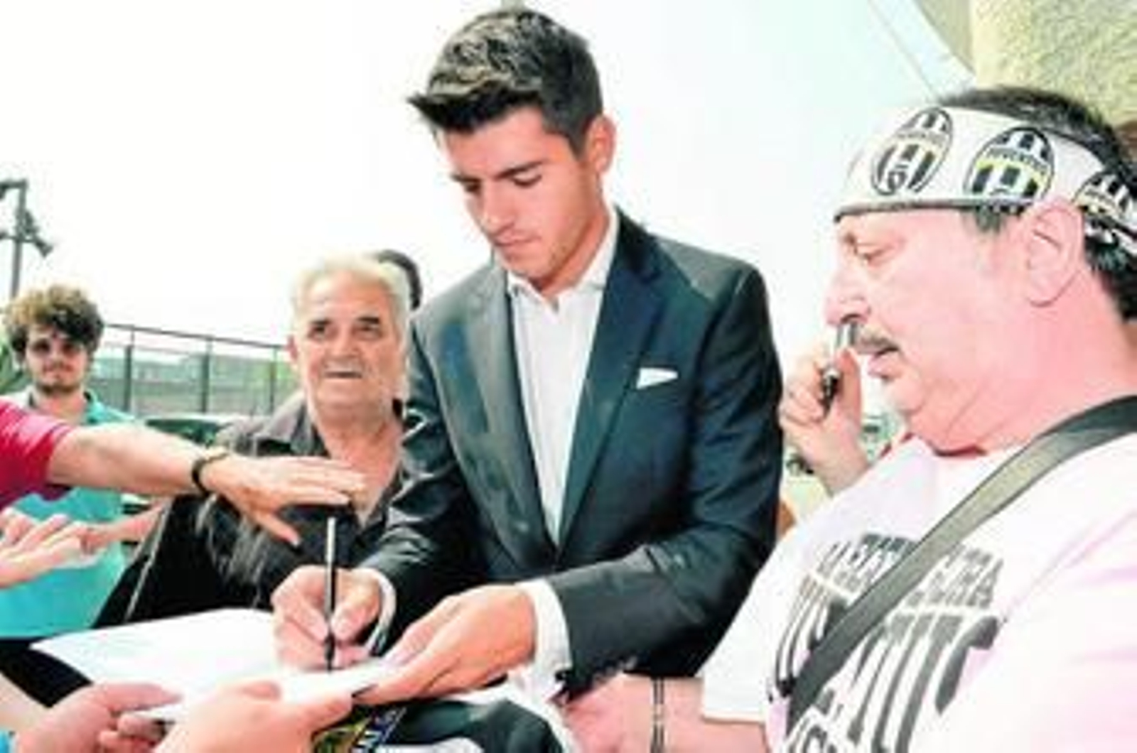 Álvaro Morata firma autógrafos a los aficionados de la Juventus después de superar el reconocimiento médico con el equipo italiano.