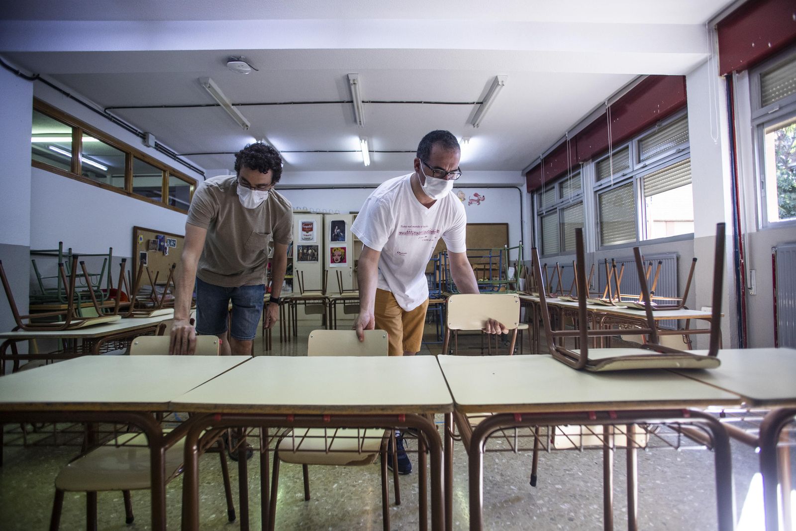 Dos docentes preparan un aula.