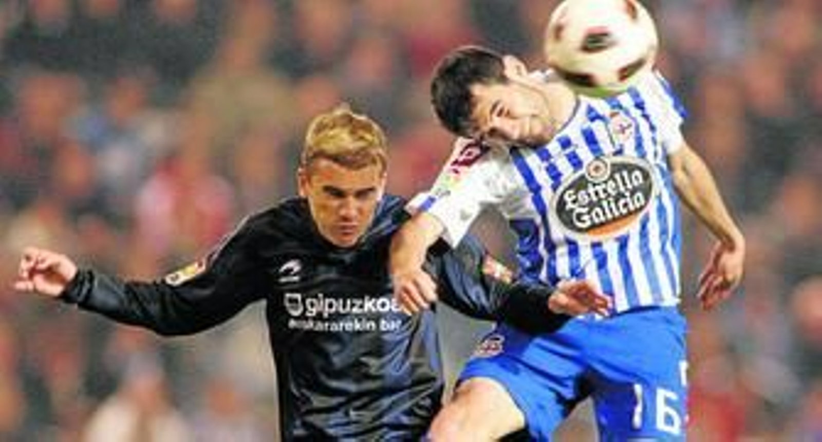 Antonio Tomás consigue despejar el balón de cabeza en presencia del jugador de la Real Sociedad Griezmann en el partido disputado esta temporada en Riazor.