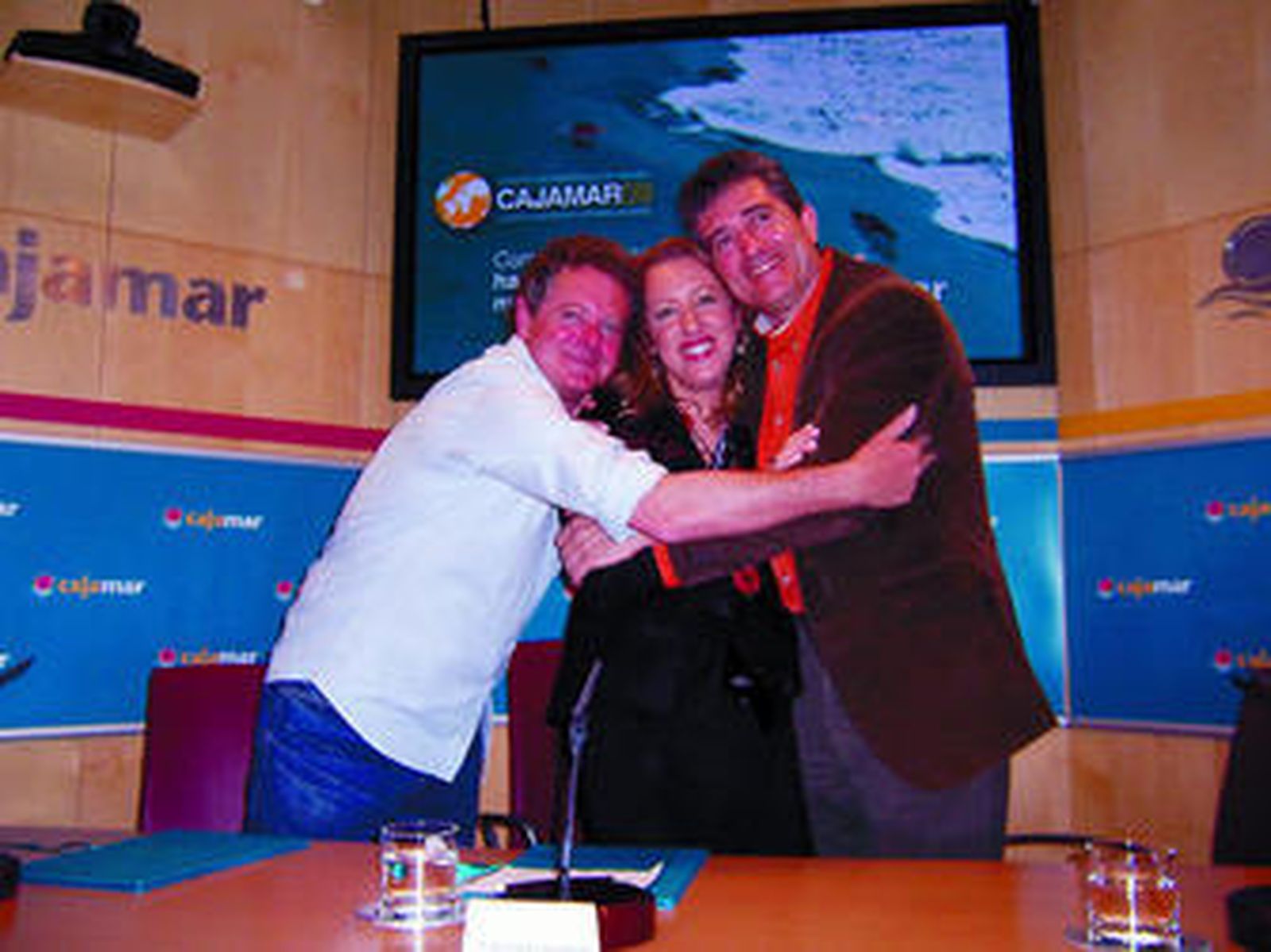 Juan Luis Cano y Guillermo Fesser abrazaron a María Giménez, tras rubricar el convenio.