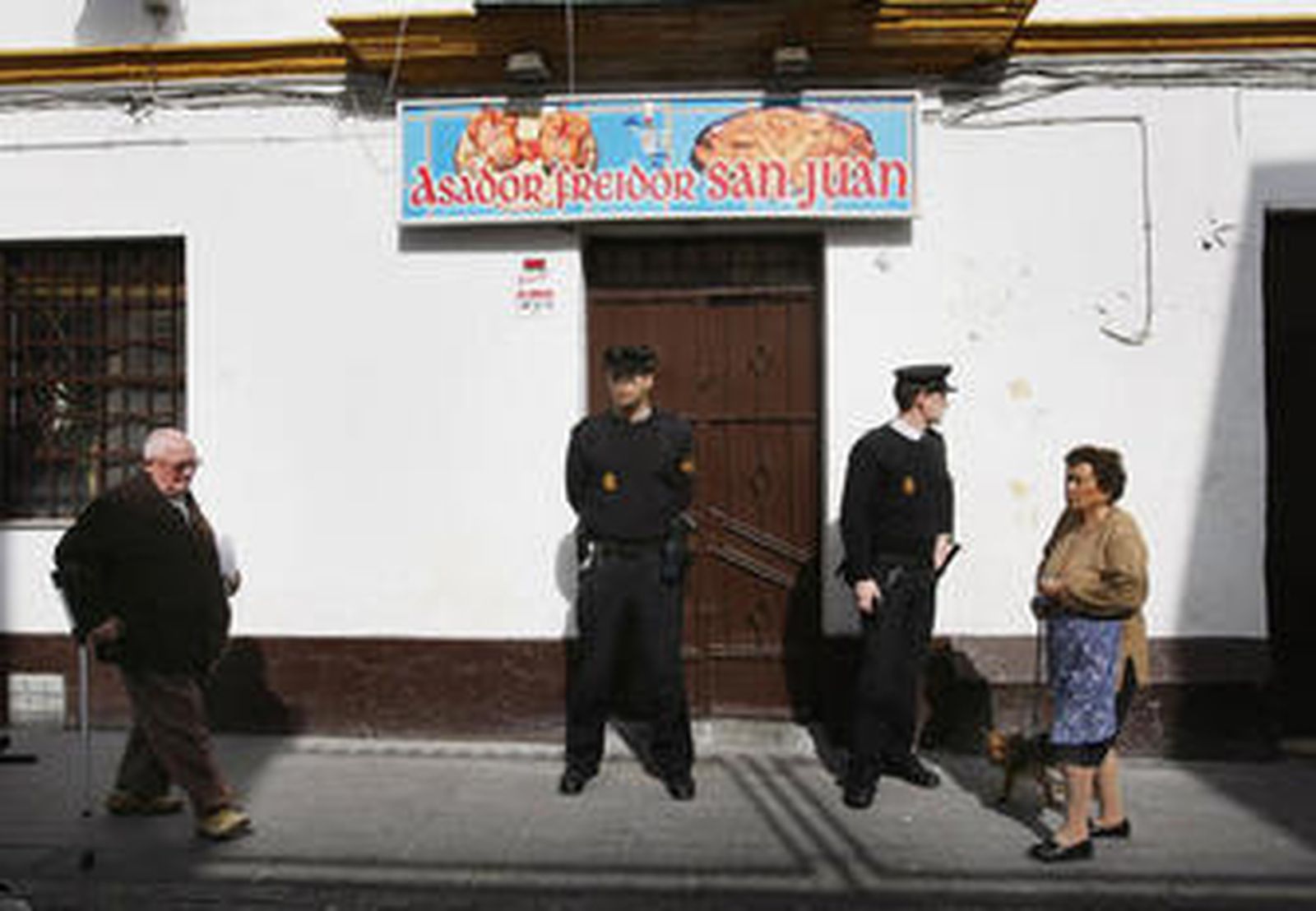 Dos policías custodian el lugar del crimen, en febrero de 2008 en El Puerto, tras la muerte de una mujer.