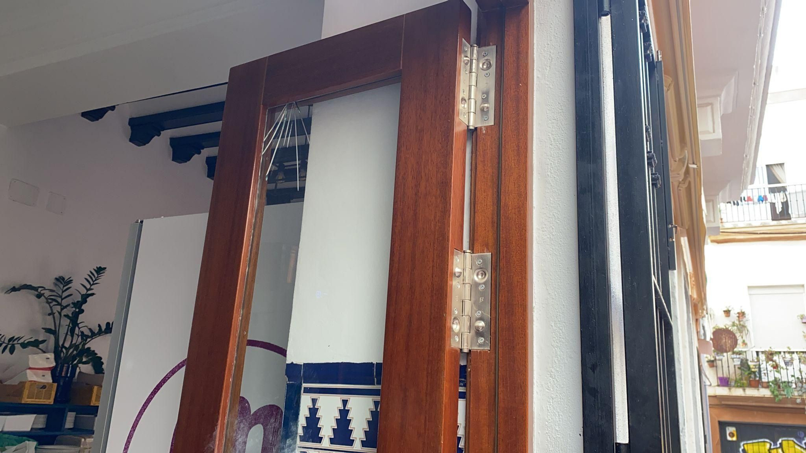 La puerta trasera del bar El Merodio con el cristal fracturado.