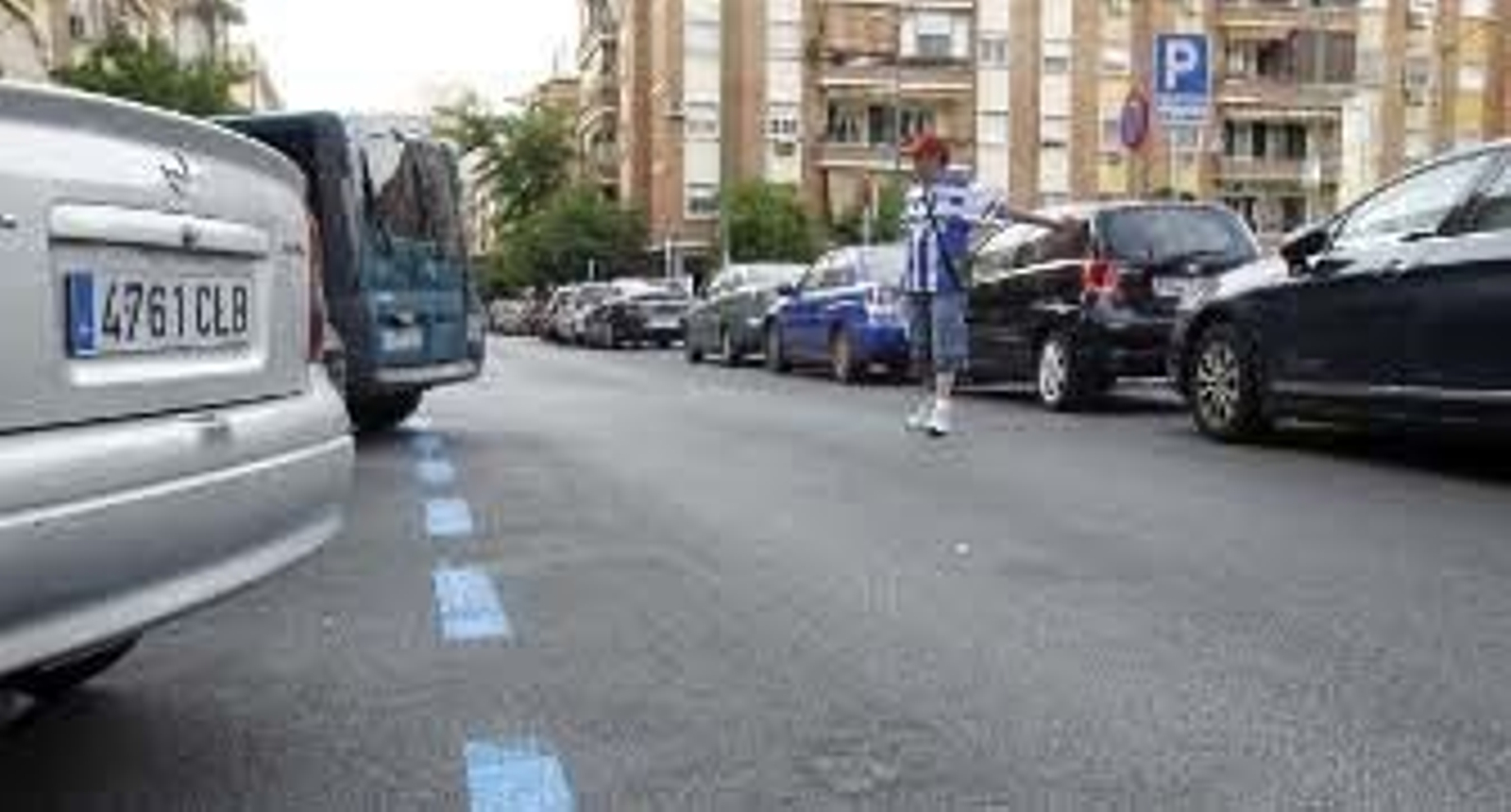 Un 'gorrilla' ayuda a aparcar en la Plaza Rafael Salgado, en la que ya está pintada la zona azul que entrará en funcionamiento la próxima semana. / Juan Carlos Muñoz