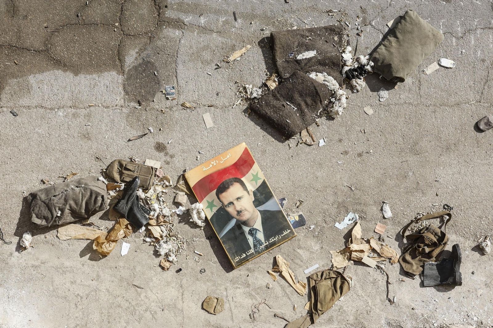 Un retrato del ex presidente Al Asad en el suelo en una base en las afueras de Damasco.