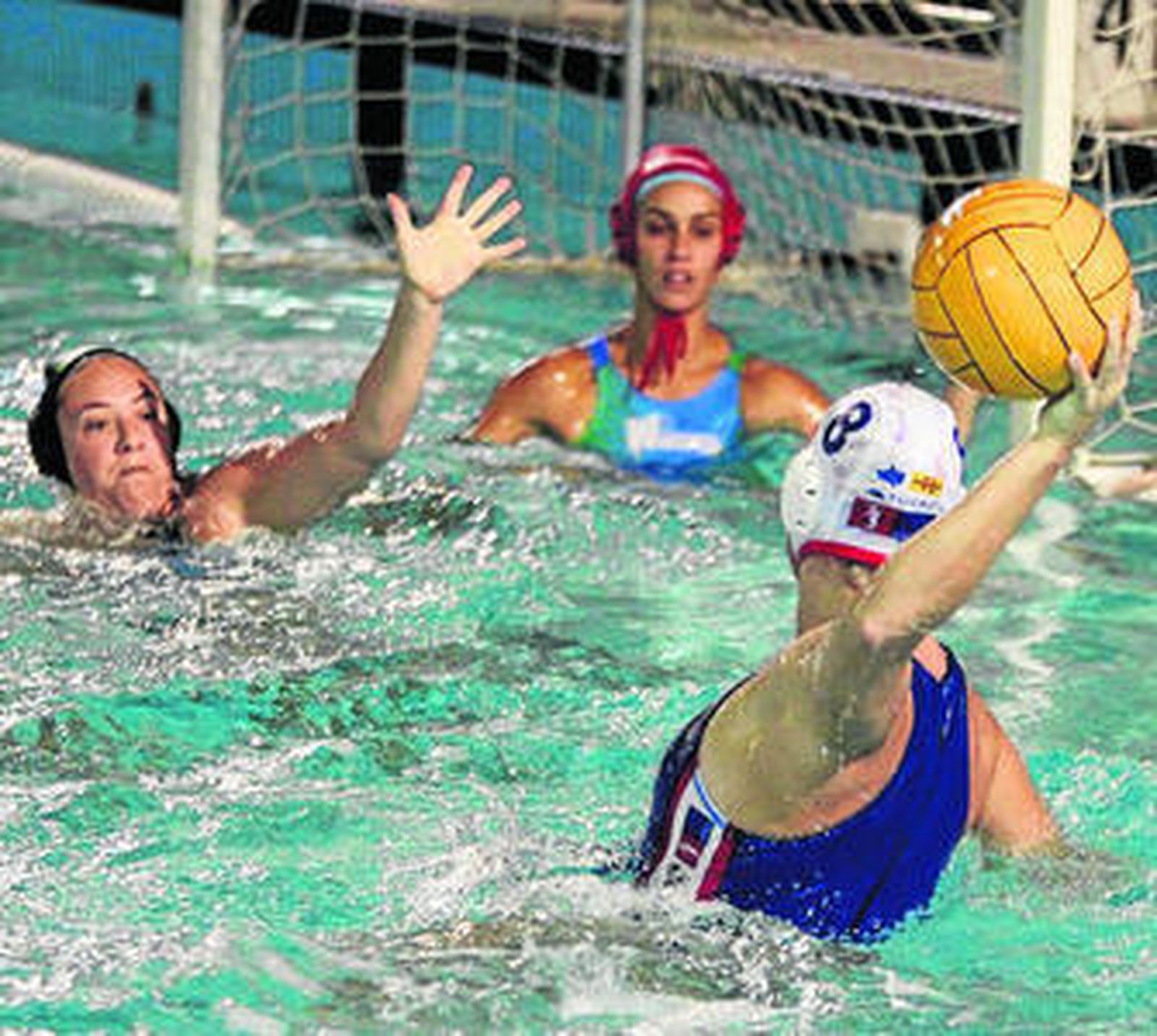 La jugadora del Mataró Gibson se dispone alanzar ante Hudyn y De la Torre.