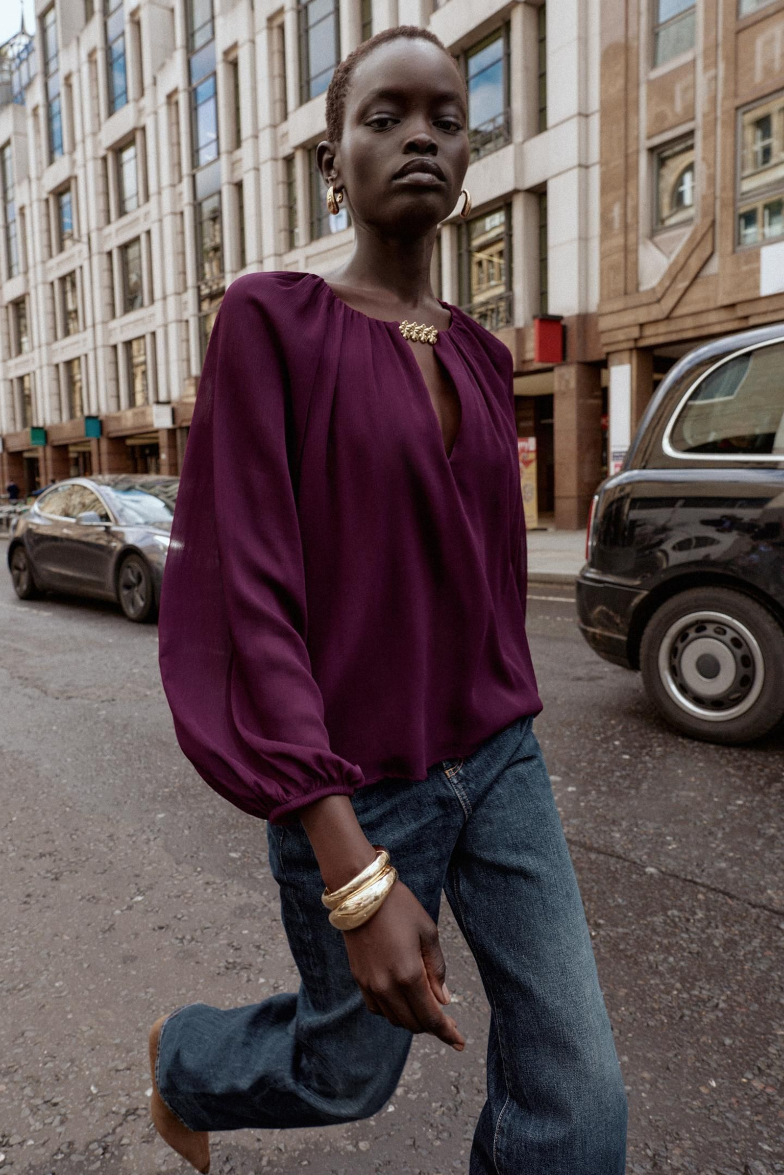 Blusa con detalles dorados de Zara.