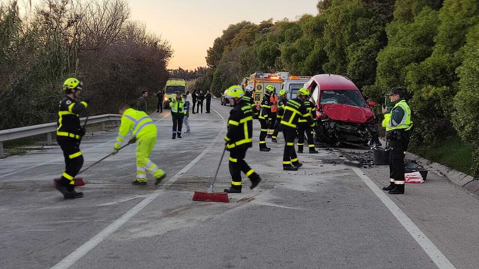 Bomberos limpiando el asfalto tras el accidente.