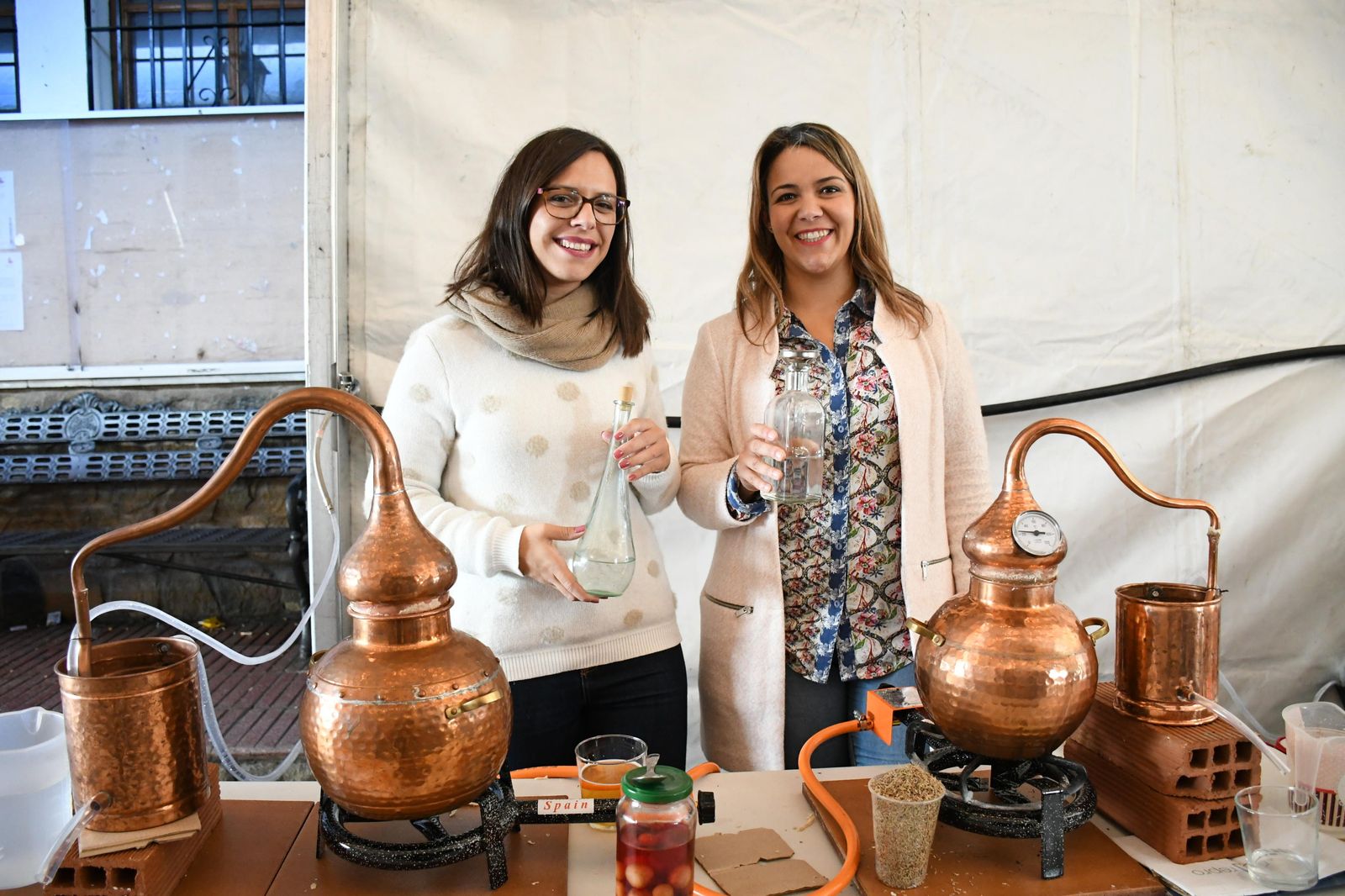 Dos participantes en el concurso para la elaboración de aguardiente de forma tradicional.
