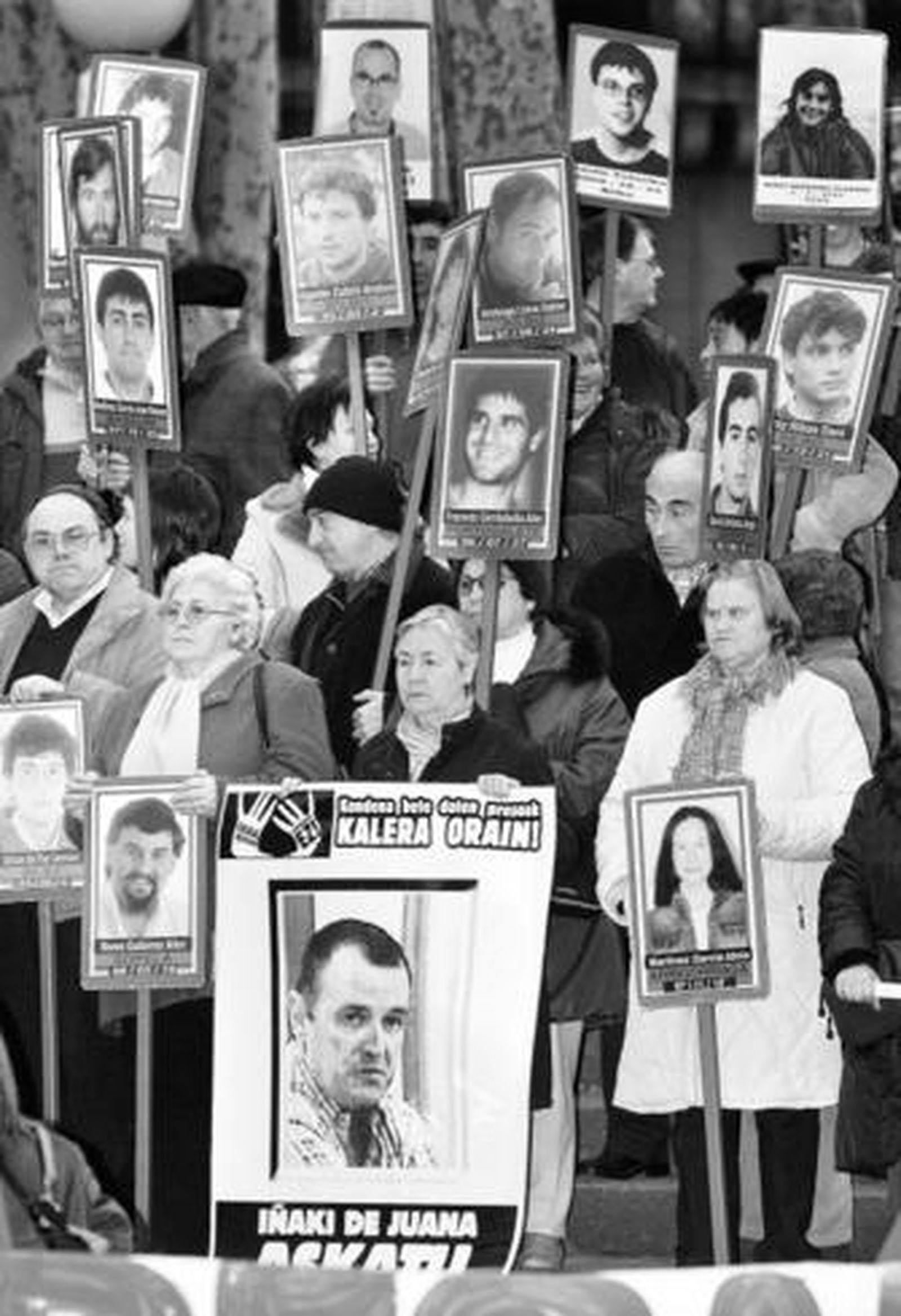 Familiares y miembros de Askatasuna, la red de apoyo a los presos de ETA, portan pancartas con sus rostros.