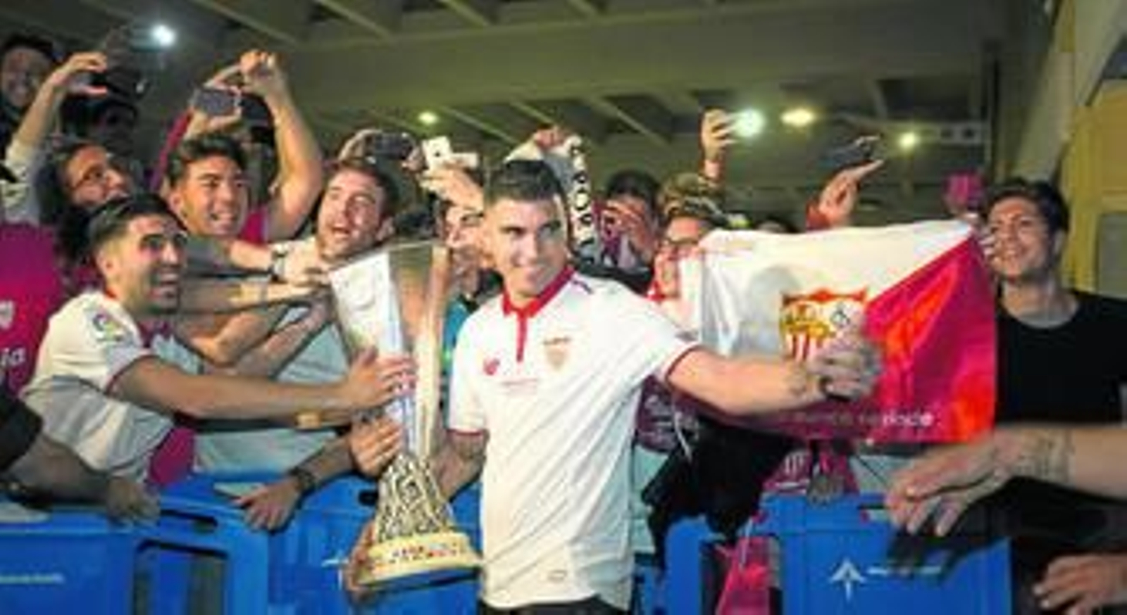 Reyes ofrece el trofeo de la Liga Europa a los numerosos aficionados que madrugaron para recibir al pentacampeón en el aeropuerto de San Pablo.