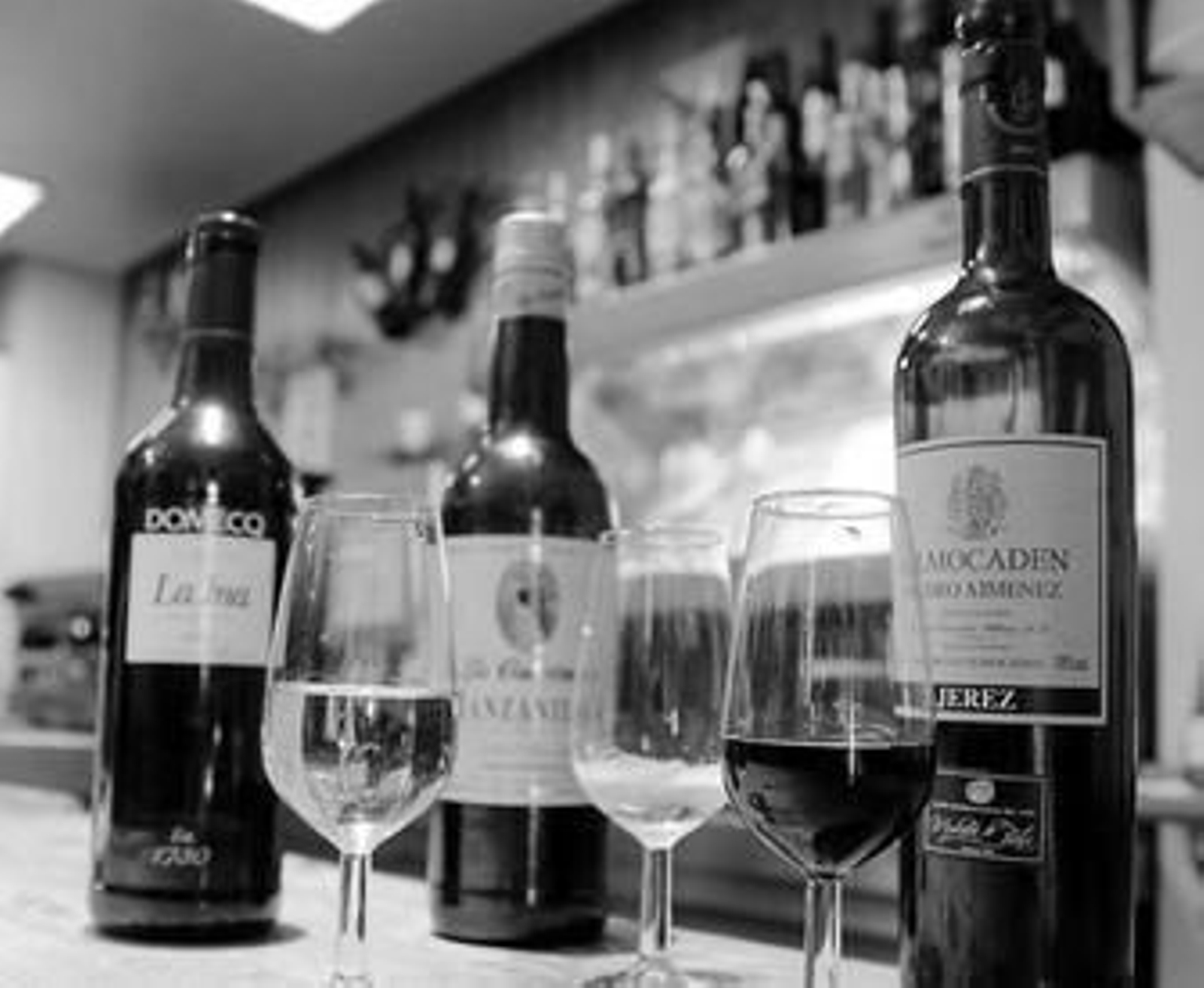 Bodegón con botellas y copas de fino, manzanilla y Pedro Ximénez en un bar de Jerez.