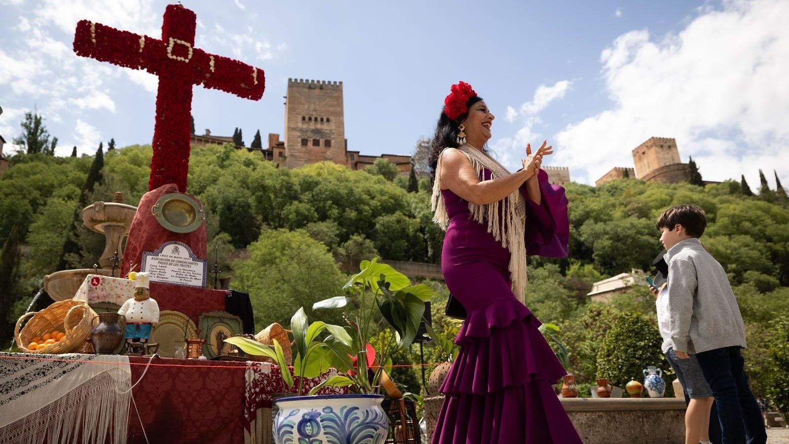 Una mujer baila frente a la Alhambra en el Día de la Cruz