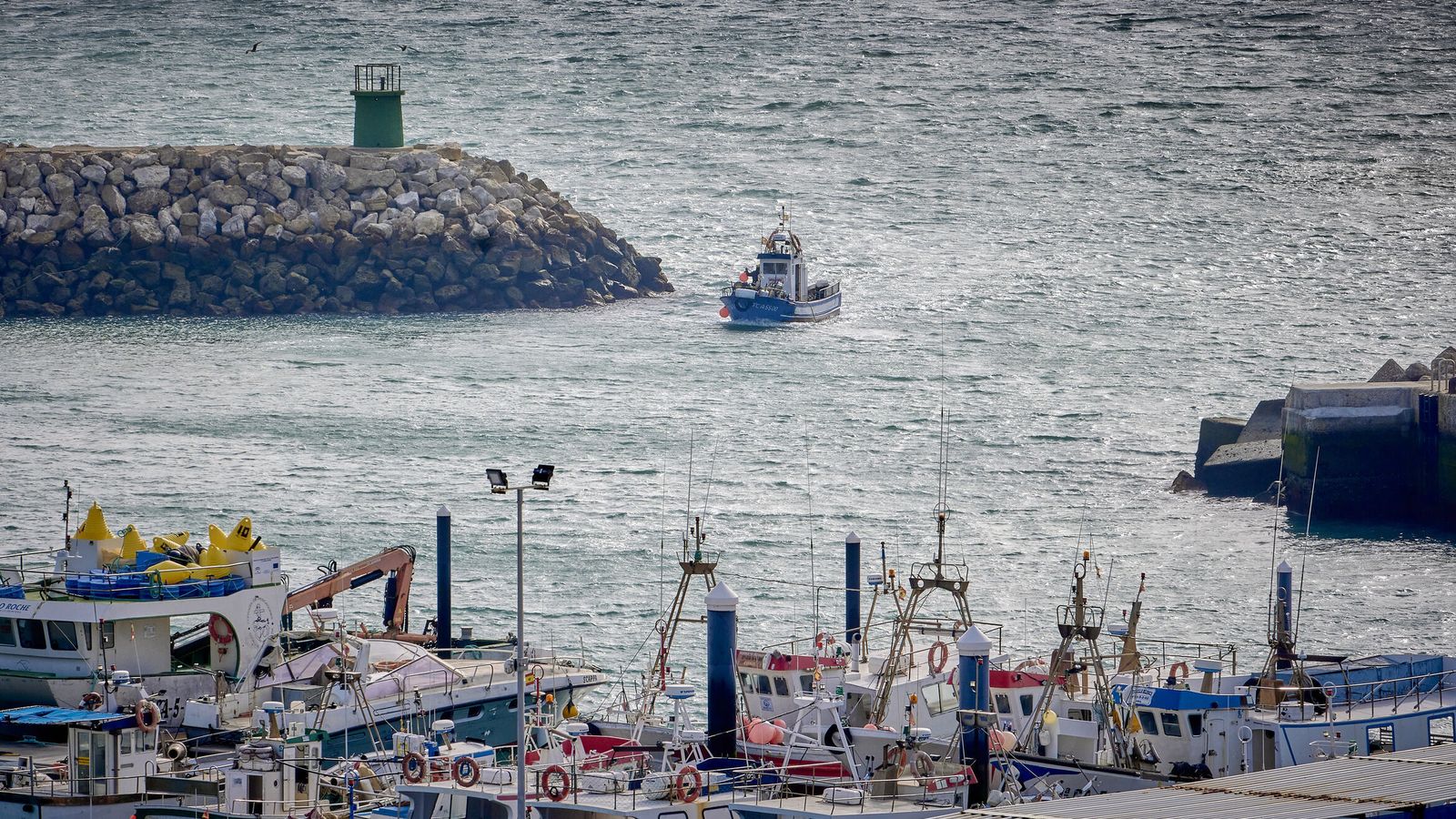 Un barco entrando por la bocana del puerto de Conil.