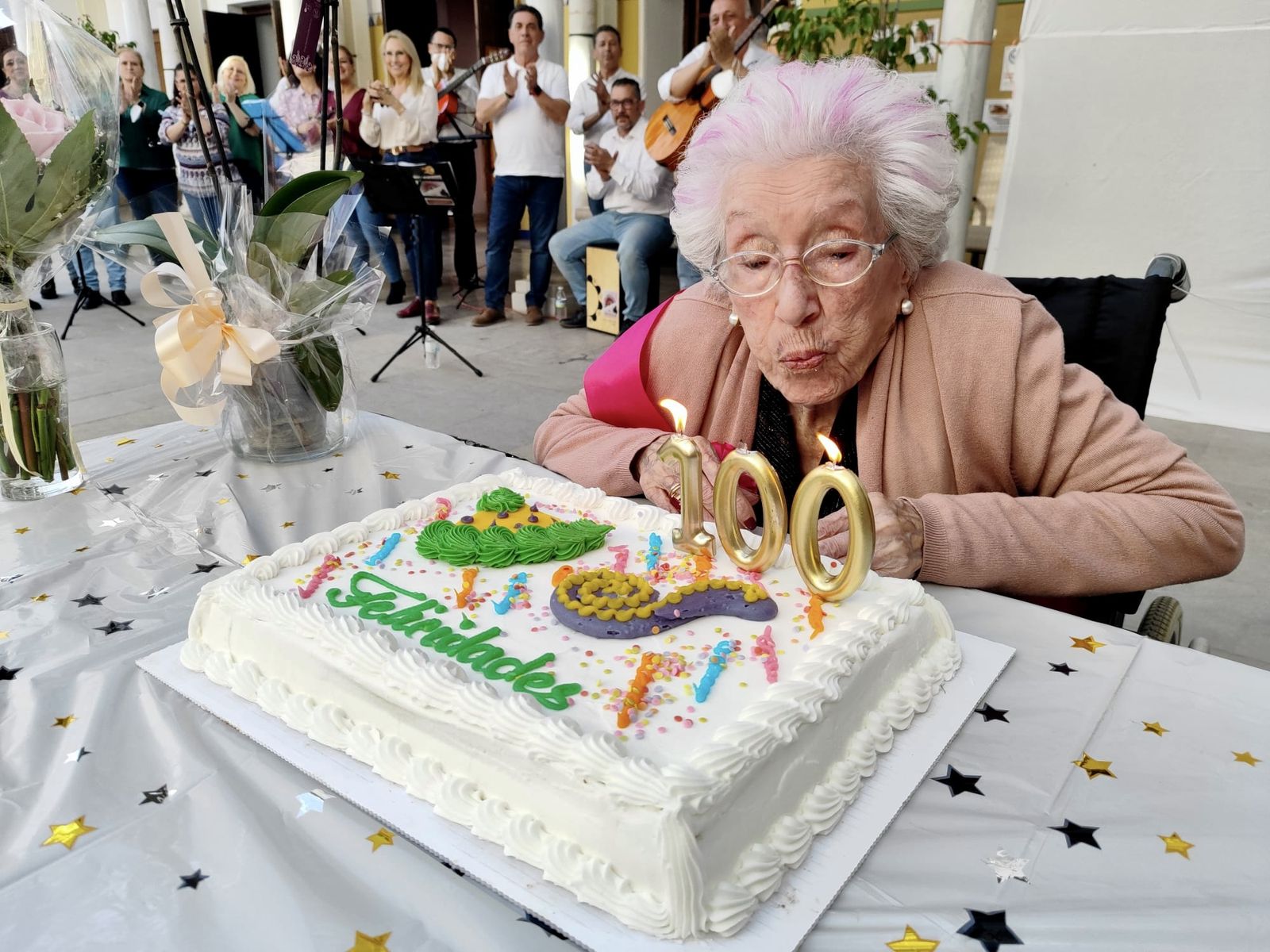 Una mujer sopla las velas de su 100 cumpleaños