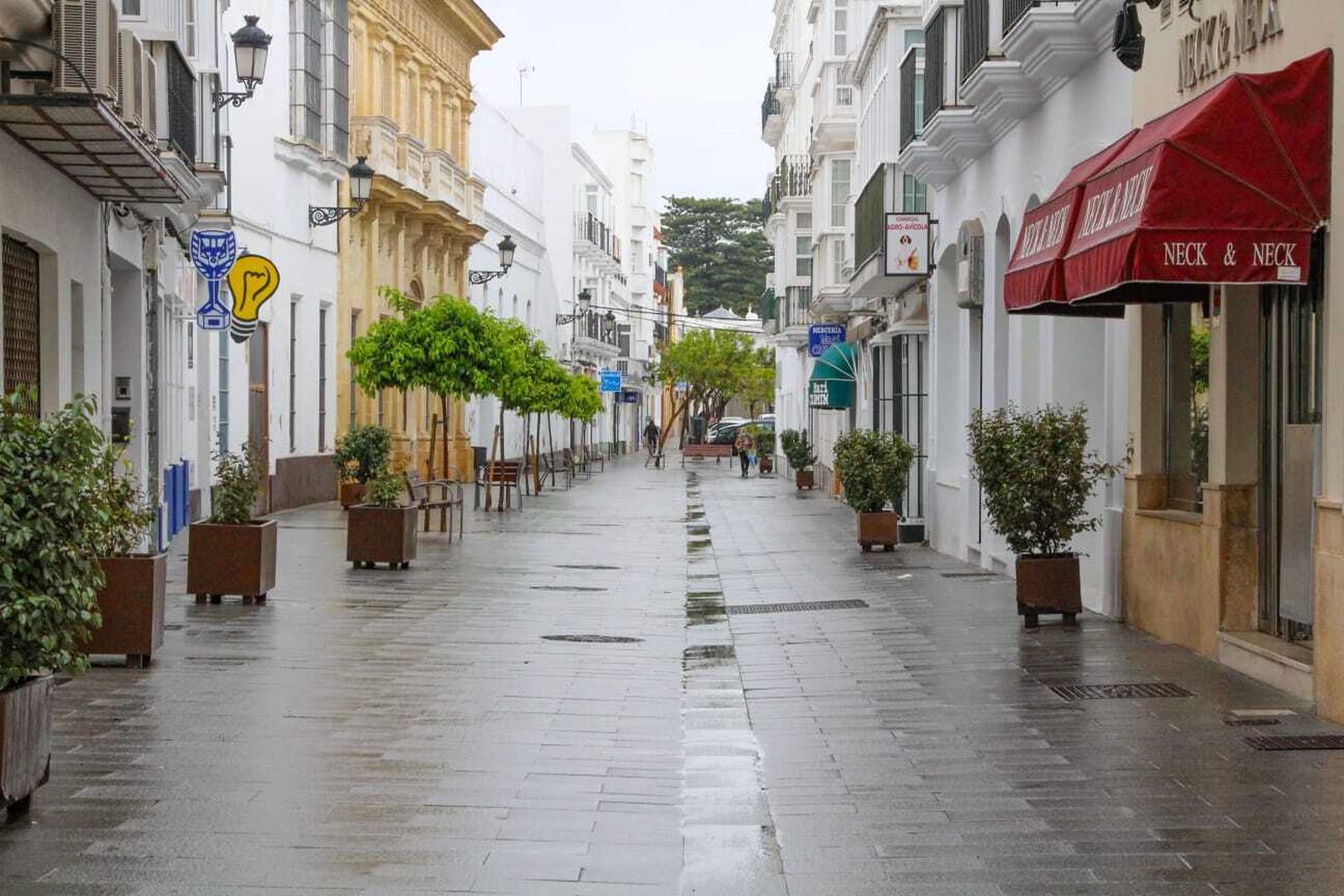 Vista de una céntrica calle de Chiclana con todos los establecimientos comerciales y de hostelería cerrados.