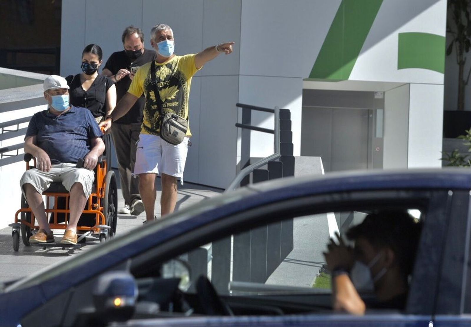 Varias personas salen del hospital Macarena con sus mascarillas.