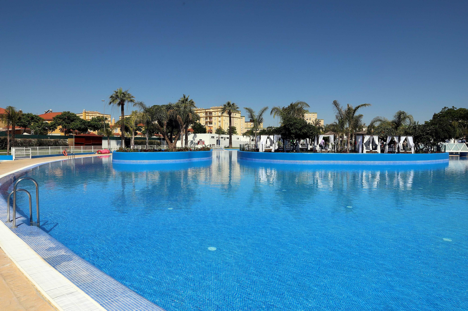 Imagen de la piscina remozada, con las balinesas que se han instalado al fondo de la imagen.