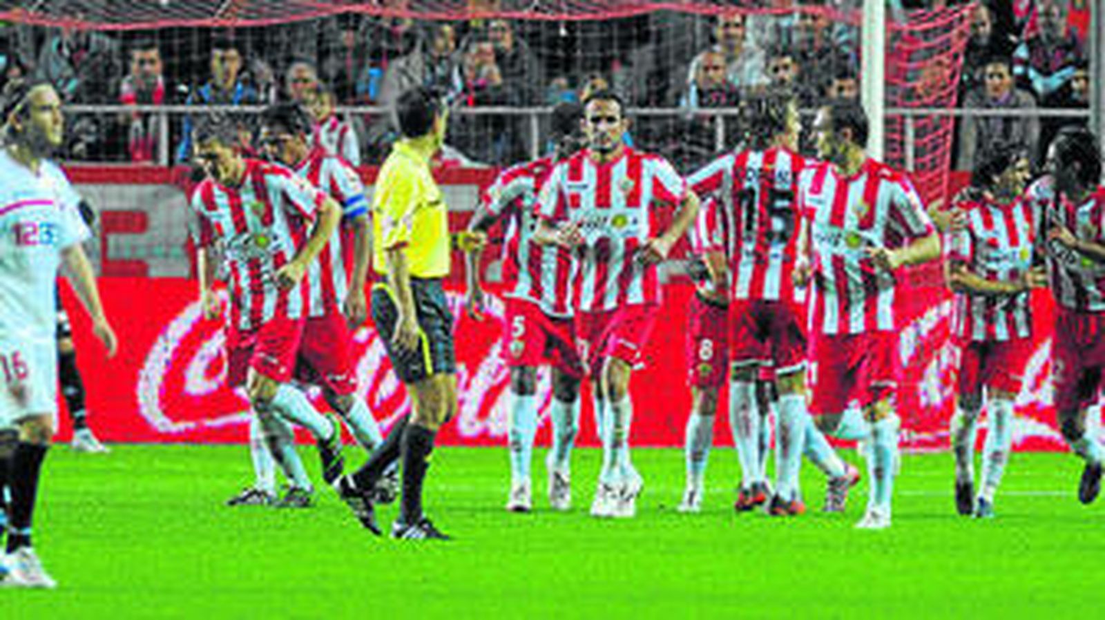 Los jugadores del Almería celebran un gol en presencia de un cariacontecido Capel, ayer.