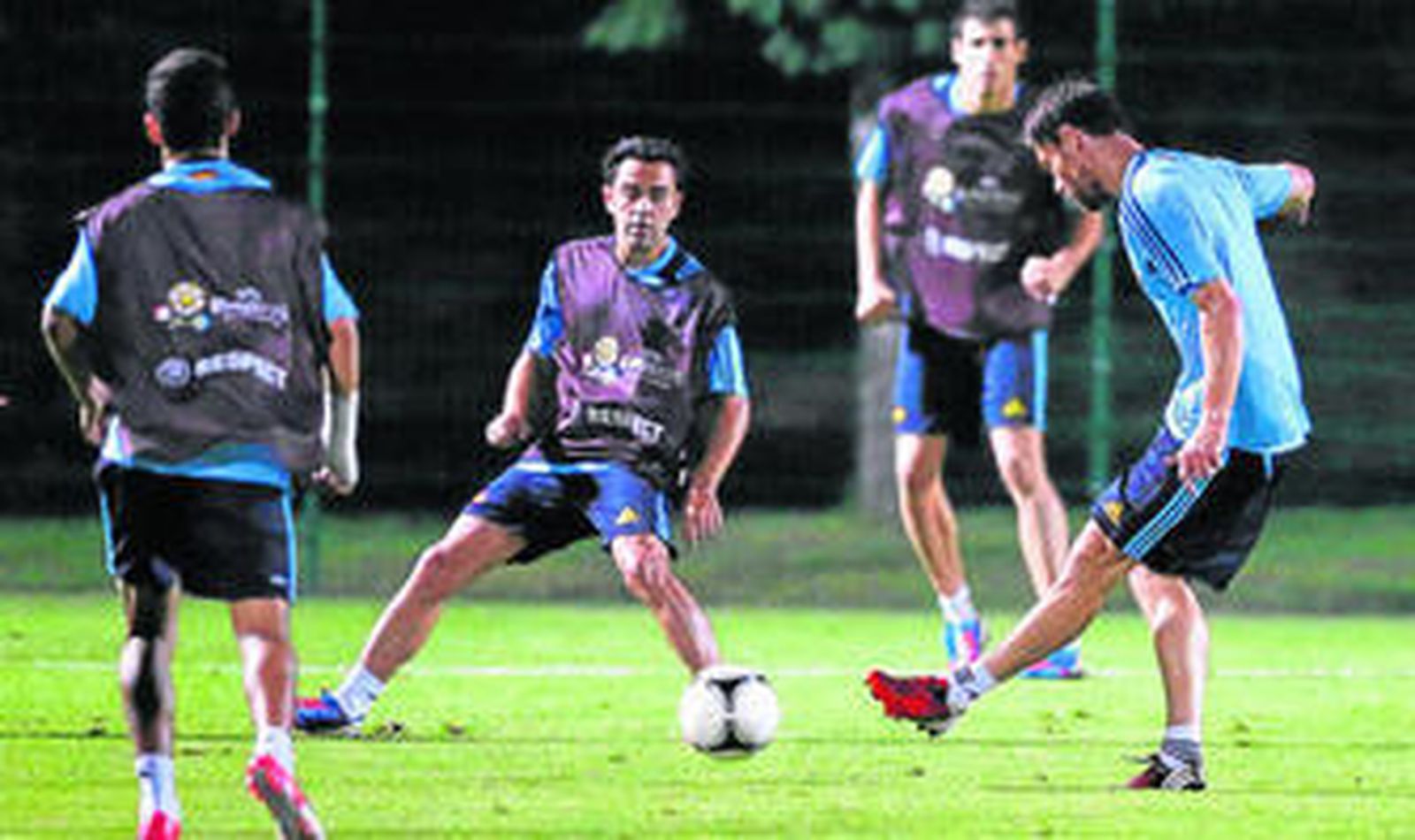 Xabi Alonso trata de realizar un pase ante la mirada de Xavi y la presencia de Jesús Navas y Javi Martínez.