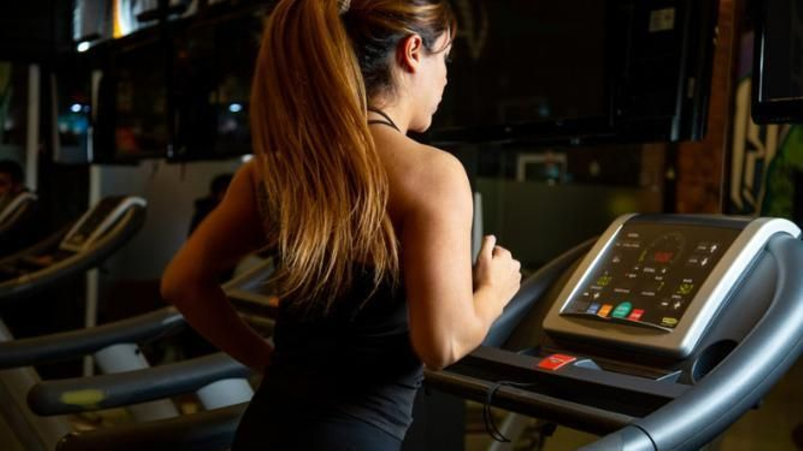 Mujer corriendo en la cinta estática en el gimnasio.