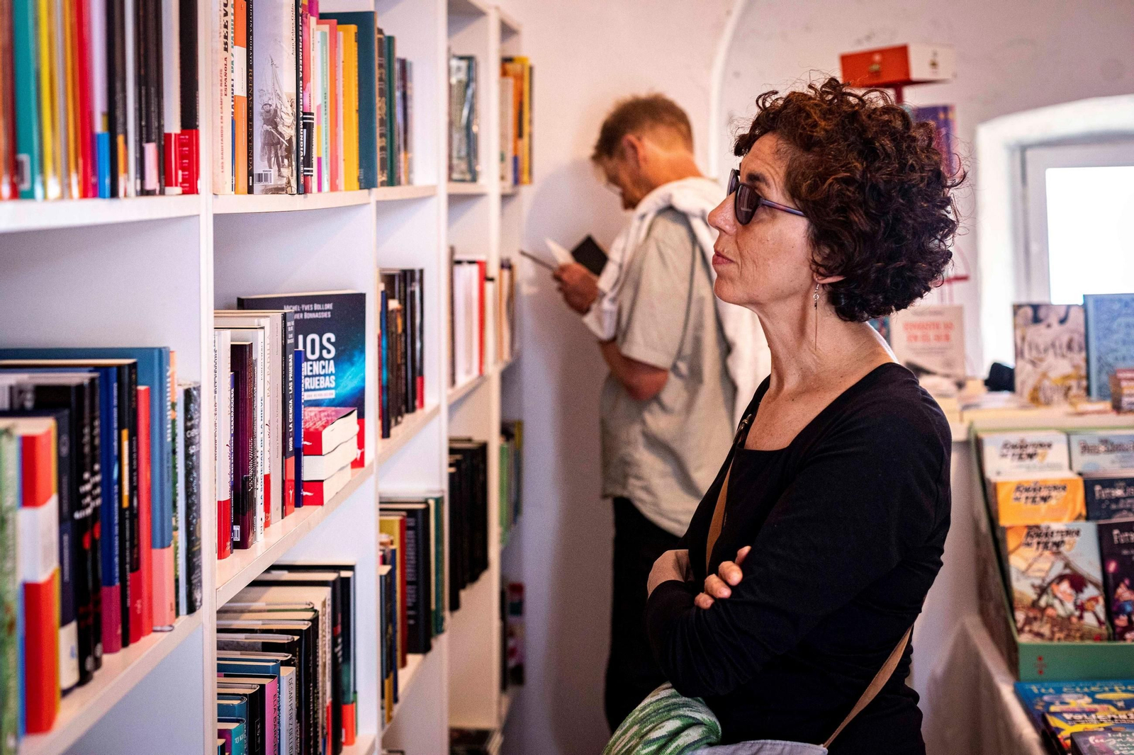 Una mujer mirando en los estantes de libros Una mujer mirando en los estantes de libros