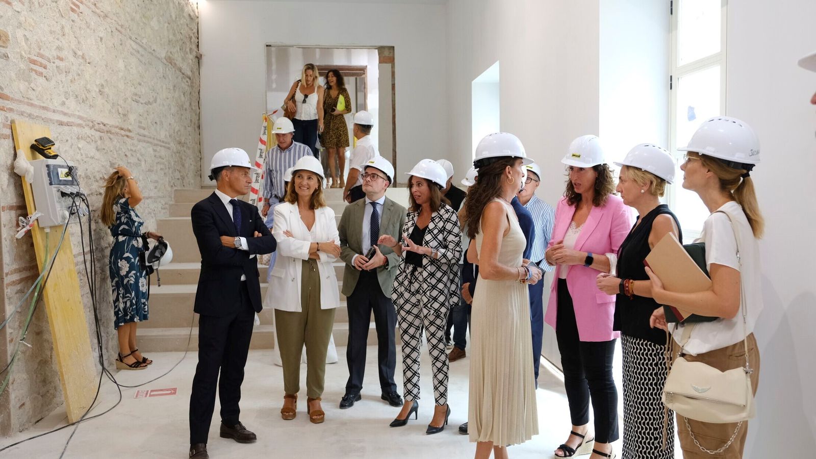 La comitiva de inspección de obras, junto a los paños de ladrillo recuperados y a la vista