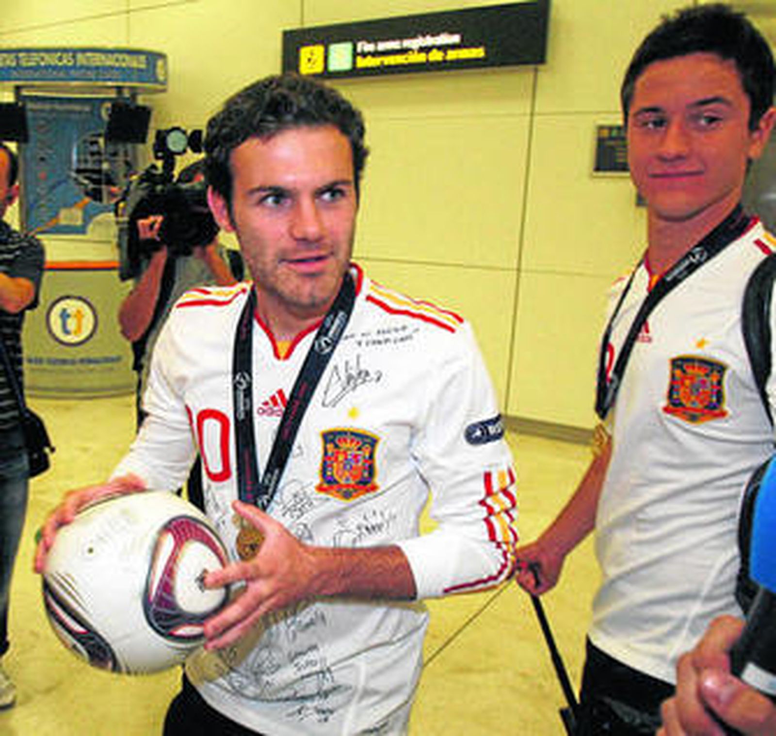 Mata (i) observa a un periodista, con Ander Herrera a su lado, tras la llegada de la sub'21 a Barajas.