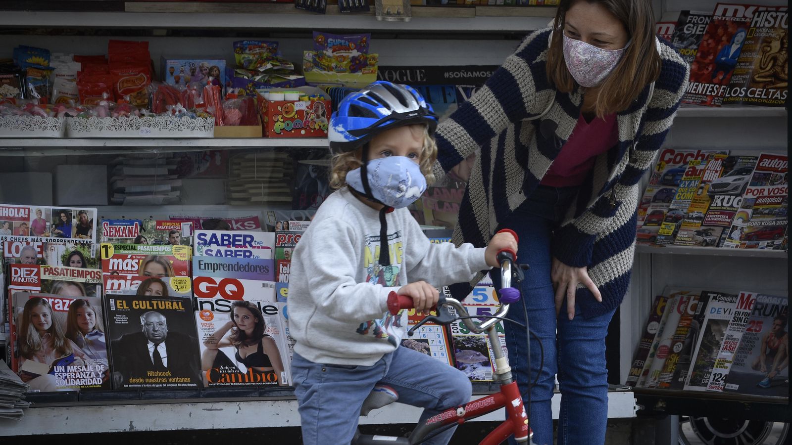 Una madre con su hijo tras comprar en un quiosco.