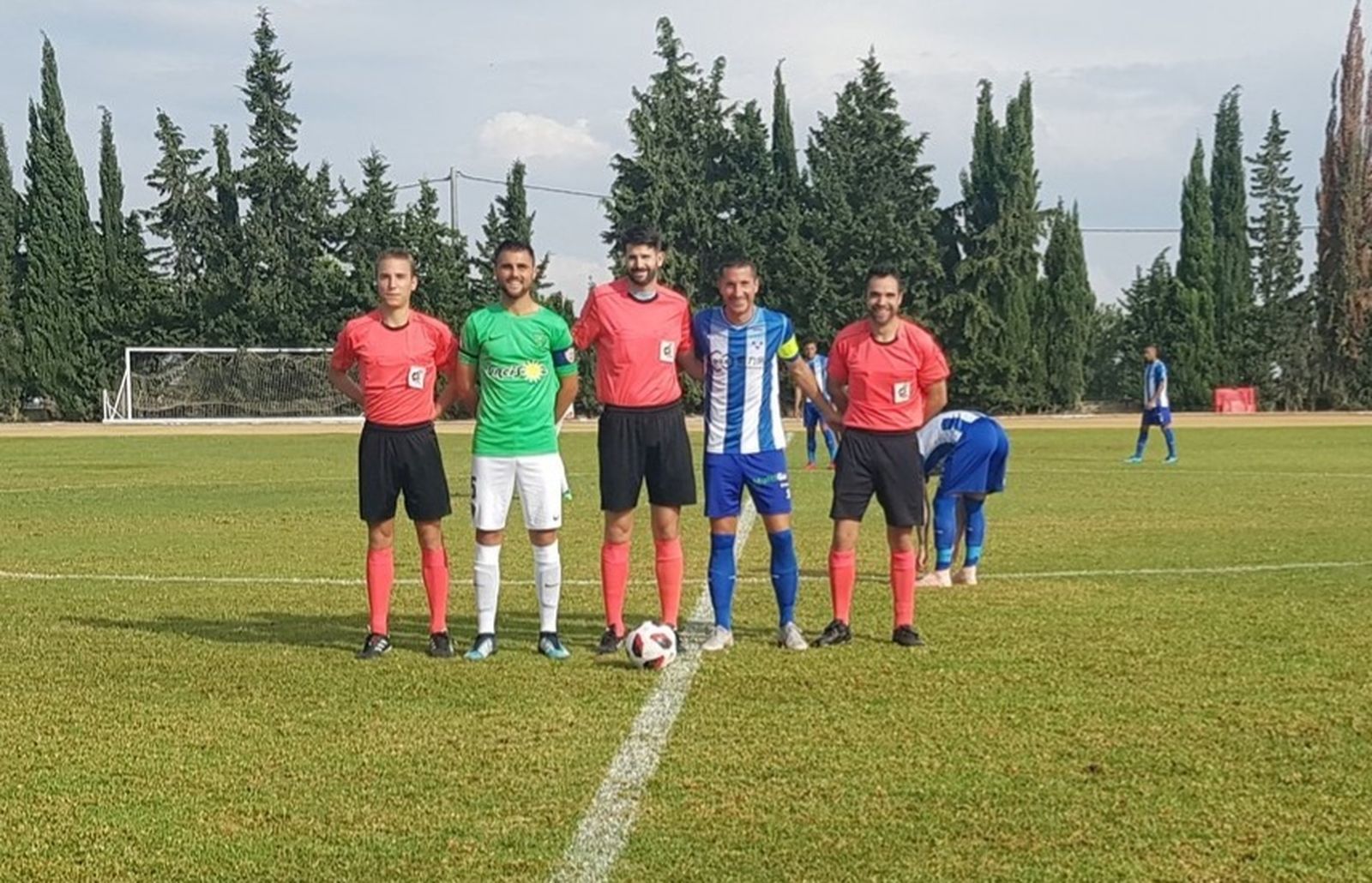 Los capitanes con el trío arbitral.