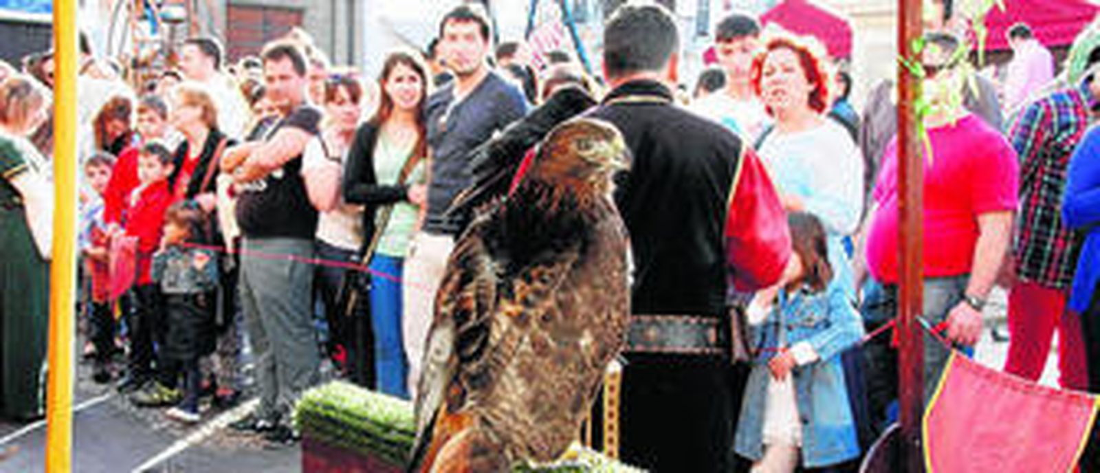 1. Son muchos los que no pueden esperar hasta la 'Exhibición de vuelo' y van al stand de las aves. 2. Un barril situado en la calle Luna transformado en una tienda que vende bebidas artesanales. 3. Un alfarero ayuda a un niño a fabricar su pieza de cerámica. 4. El puesto de chucherías es otro de los más visitados.