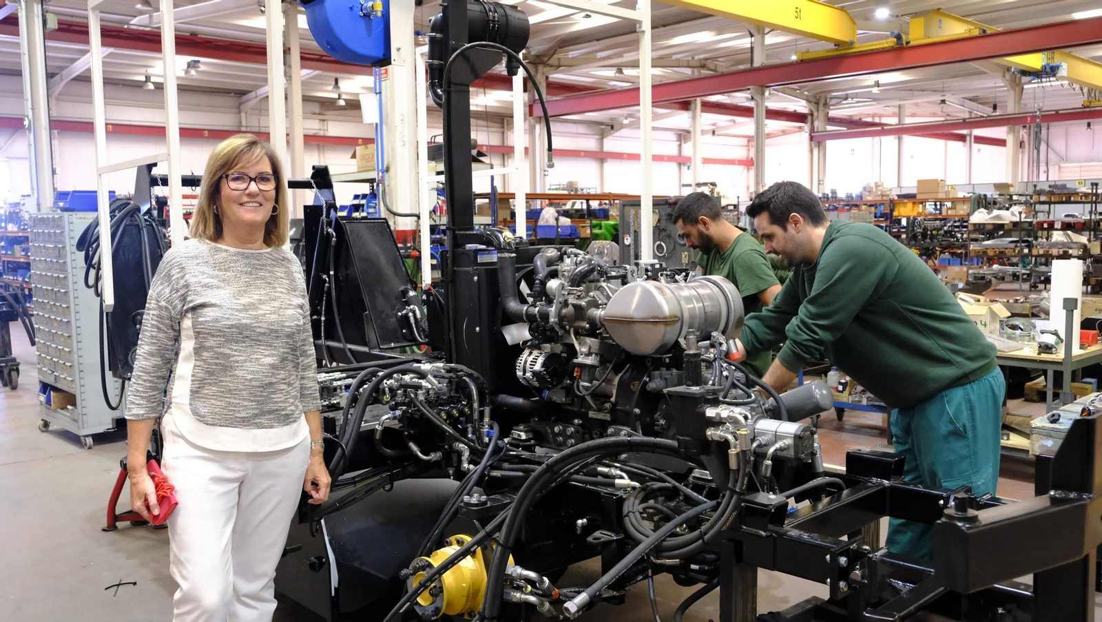 Inmaculada Piquer, en el centro de fabricación de Piquersa donde dos  operarios ensamblan el motor de una limpiadora.