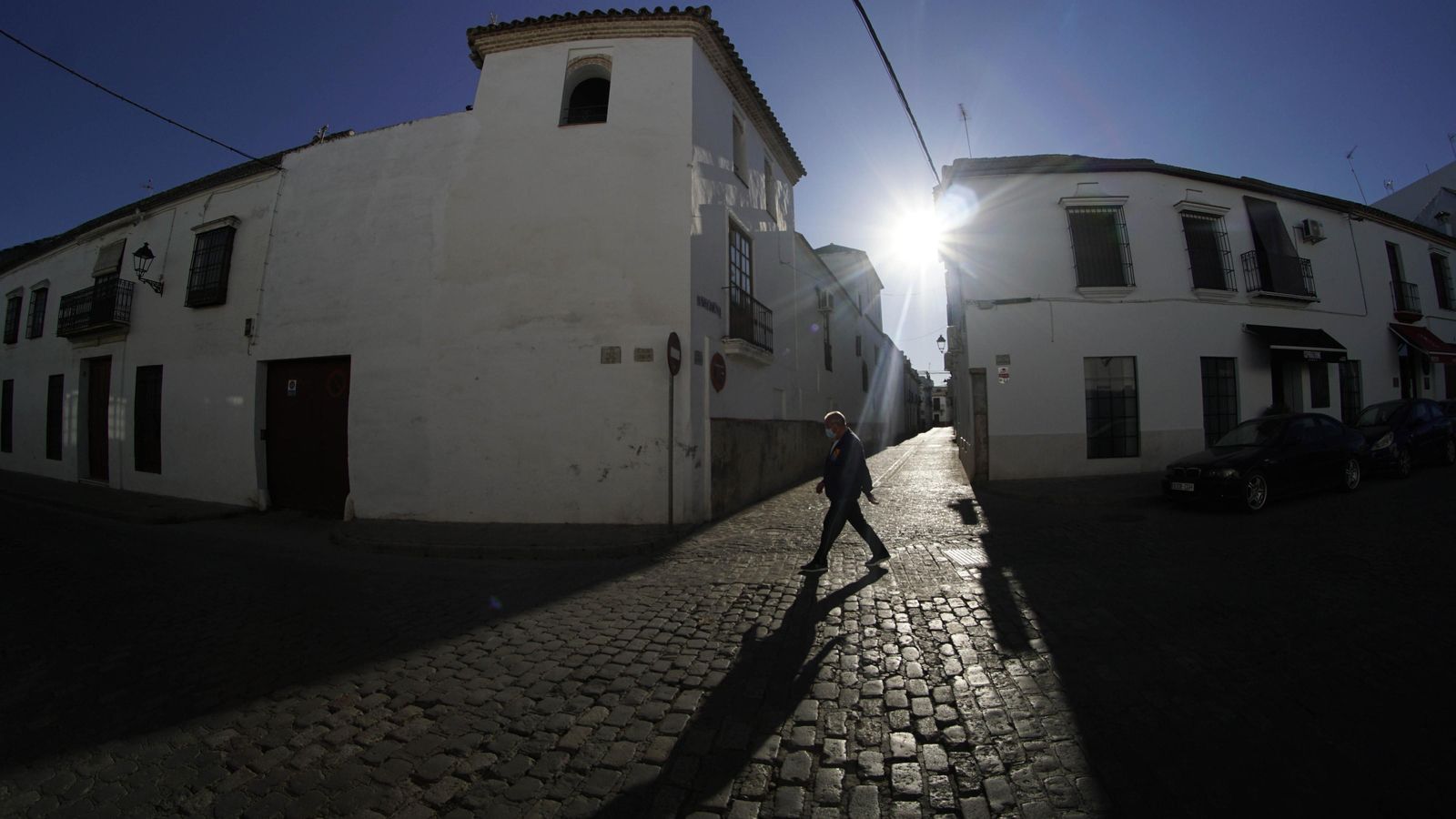 Un hombre pasea por una solitaria calle de Écija.