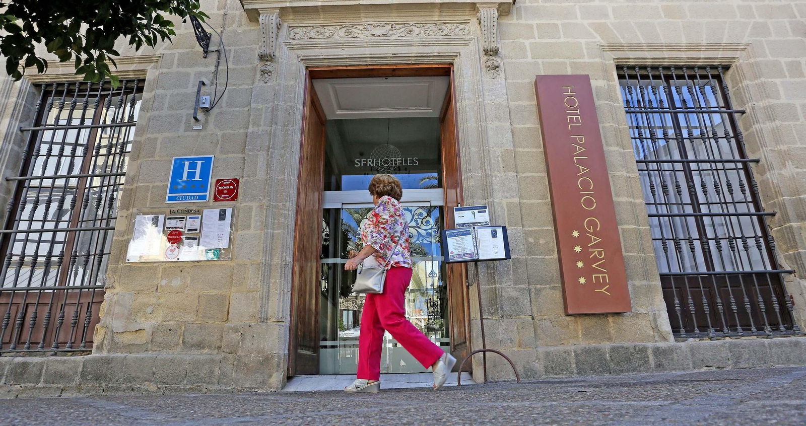 Una mujer pasa ante la puerta de uno de los hoteles de la plaza Rafael Rivero.