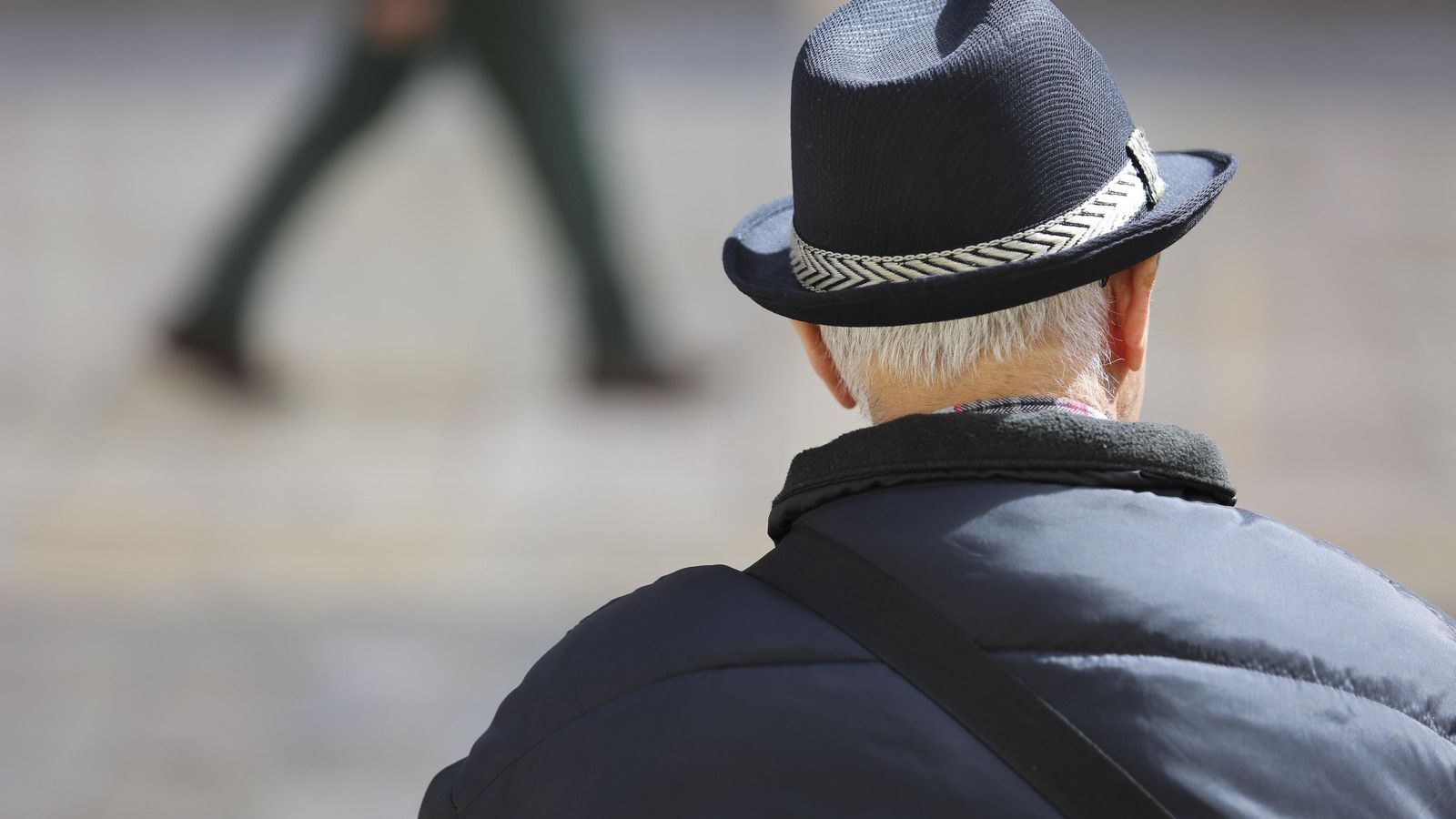 Un señor mayor sentado en un banco.