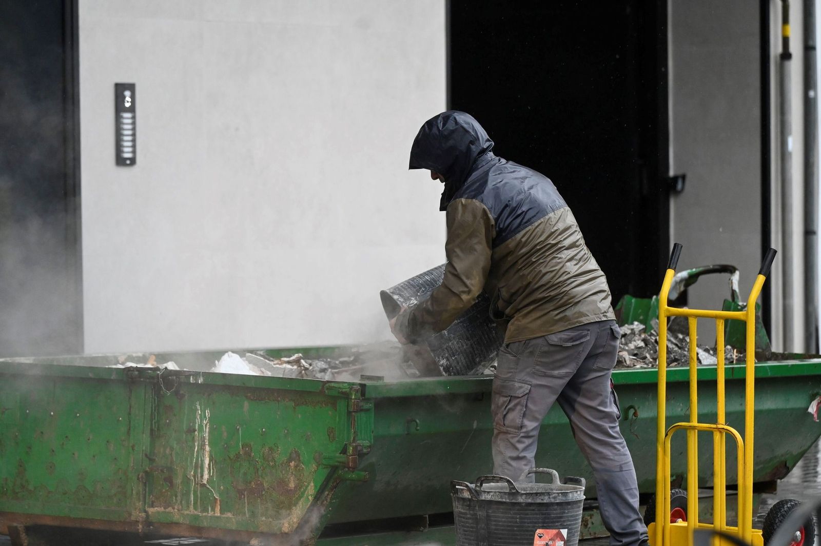 Un trabajador de la construcción deposita ripio en una cuba