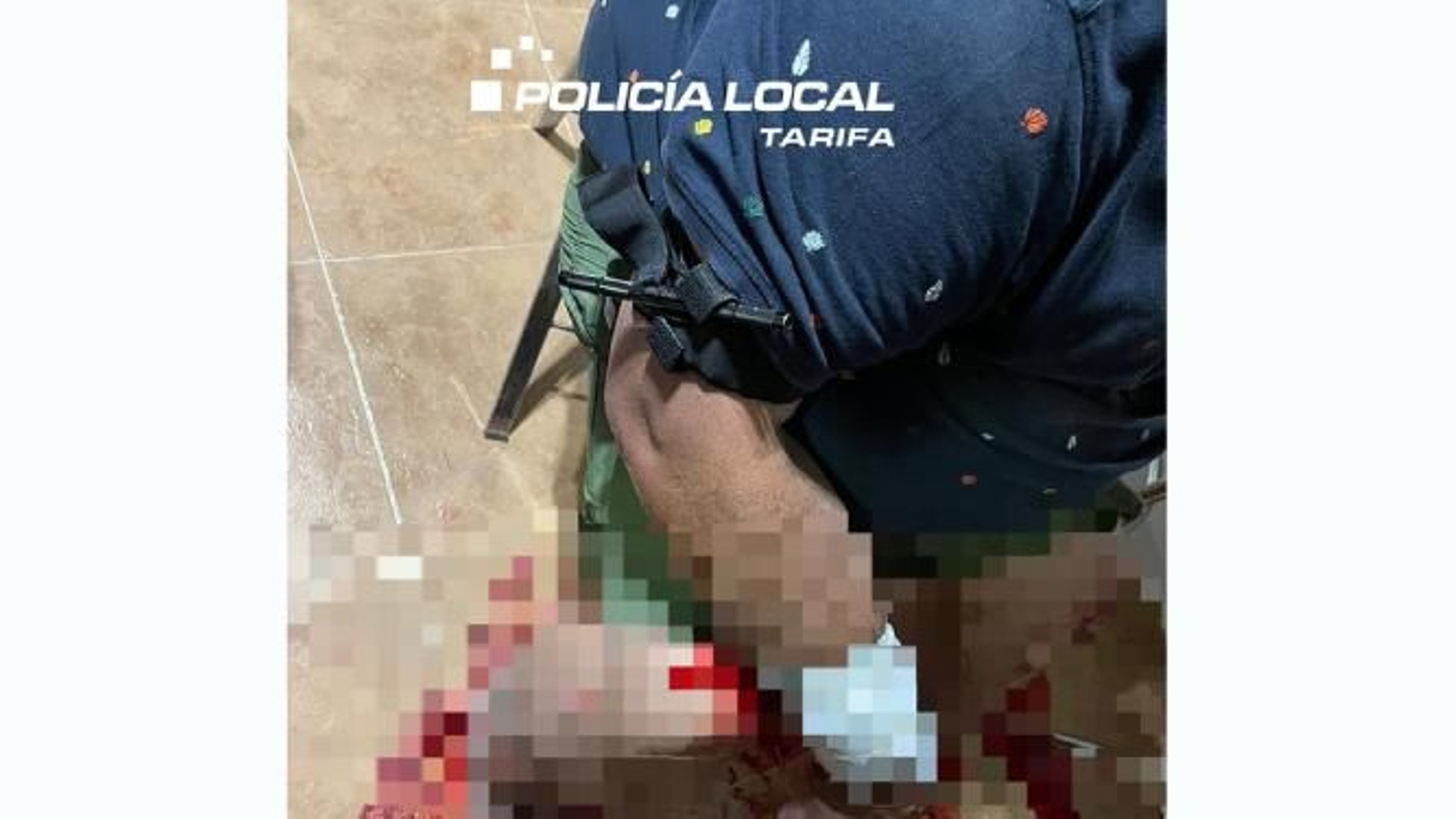 El agente de la Policía Local de Tarifa realiza el torniquete al herido.