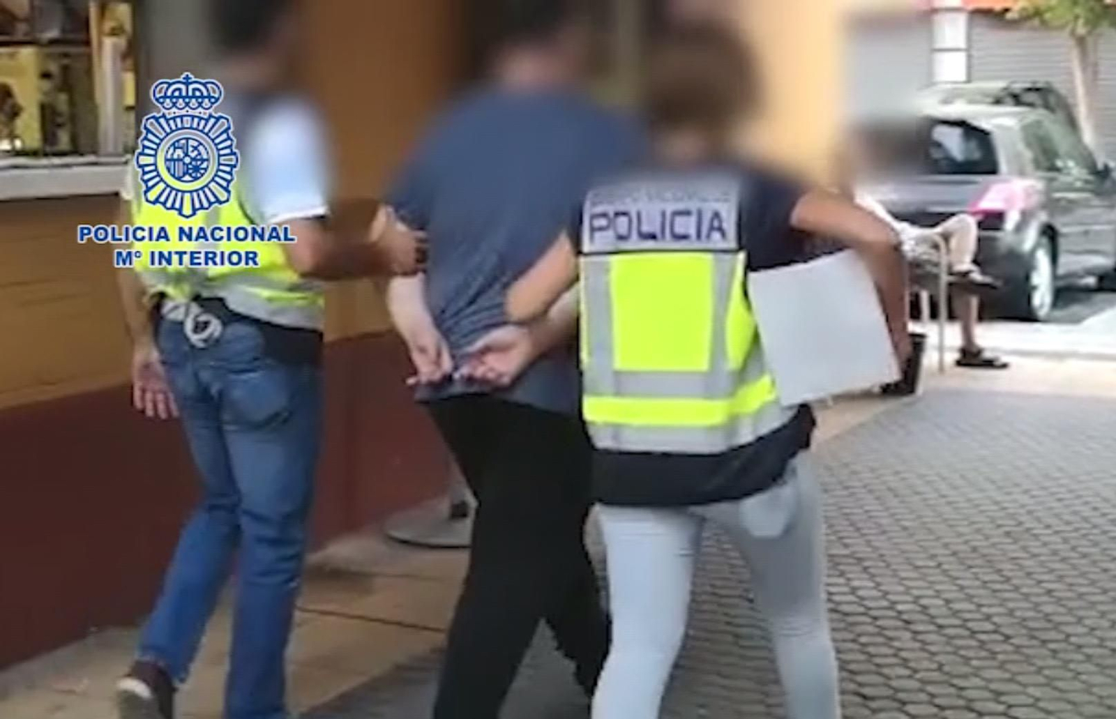 Dos policías se llevan detenido a uno de los estafadores.
